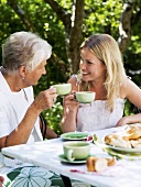 Zwei Frauen trinken Kaffee im Garten