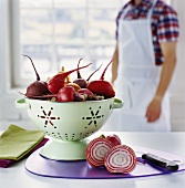 Beetroot in colander, person in background