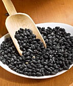 Black beans with wooden scoop on a plate