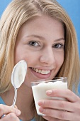 Young woman eating natural yoghurt
