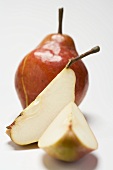 Whole red Williams pear and two wedges of pear