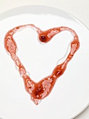 Heart drawn in cranberry sauce on plate