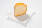 A piece of Gouda cheese on paper