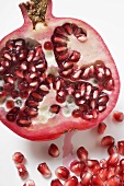 Half a pomegranate and several pomegranate seeds