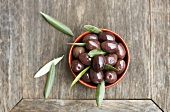Black olives with leaves in bowl