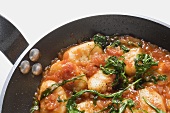 Gnocchi in tomato sauce with rocket in frying pan (detail)