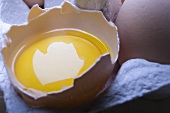 Ein aufgeschlagenes Ei im Eierkarton