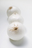 Drei weiße Zwiebeln in einer Reihe