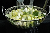 Washing chopped spring onions in a sieve