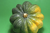 An acorn squash against a green background