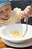 Little girl eating pasta with cheese