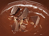 Geschmolzene Schokolade mit Schokostücken (bildfüllend)