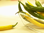 Yellow and green chillies in glass dish