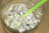 Ein Glas Mineralwasser mit Eis und Strohhalm