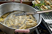 Thai cookshop: spring rolls being deep-fried