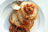 Toasted baguette slices with Bolognese sauce