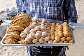 Man carrying tray of Thai pastries