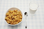 Breakfast cereal (crispy squares) and a glass of milk