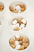 Brown and white sugar cubes in small bowls