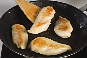 Browning chicken breasts in a frying pan