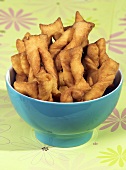 Twisted fried pastries in a blue bowl