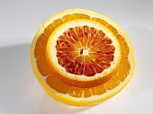 A slice of blood orange on half an orange