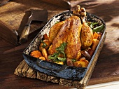 Roast chicken with root vegetables in an old roasting pan