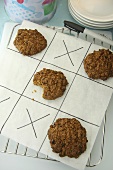 Oat cookies on a pieces of paper (noughts and crosses)