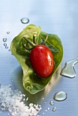 Grape tomato on a basil leaf with sea salt