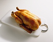 A roast duck on a chopping board