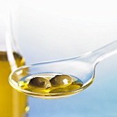 Grüne Oliven mit Öl auf Löffel