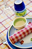 A simple place setting with a checked napkin