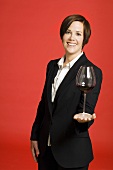 Weibliche Sommeliere hält ein Glas Rotwein auf der Hand