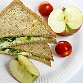 Egg and salad sandwich with tomatoes and apple