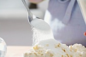 Kuchen backen: Zucker wird über Butter-Mehl-Mischung gestreut