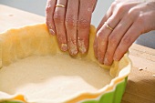 Making apple pie: lining a pie dish with shortcrust pastry