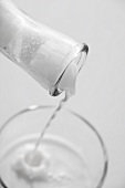 Milk being poured out of a bottle into a glass