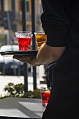 Waiter serving Campari on a tray