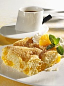 A piece of mandarin orange cake with a cup of coffee
