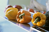 Yellow, orange and red peppers on kitchen table