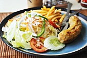 A pork sausage with salad and chips