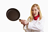 Blond female chef brandishing frying pan
