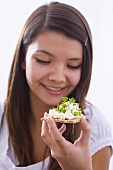 Girl holding crisp bread with cottage cheese and cress