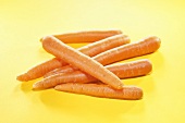 Fresh carrots on yellow background