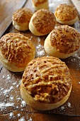 Several cheese bread rolls on a floured surface
