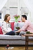 Pregnant woman and man sitting on sofa