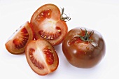 Tomatoes (variety: Kumato), whole, halved and quarter