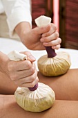 Woman receiving herbal stamp massage