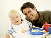 Father with baby eating in high chair