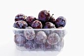 Fresh plums in plastic container